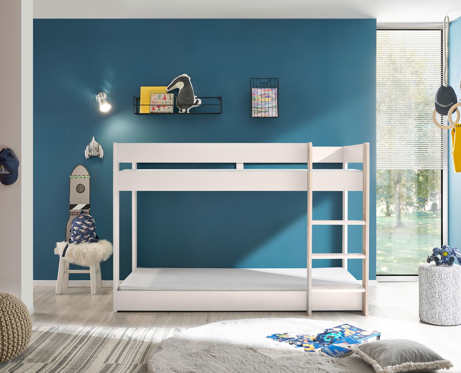Weißes Etagenbett in einem modernen Kinderzimmer mit blauer Wand, seitlicher Perspektive