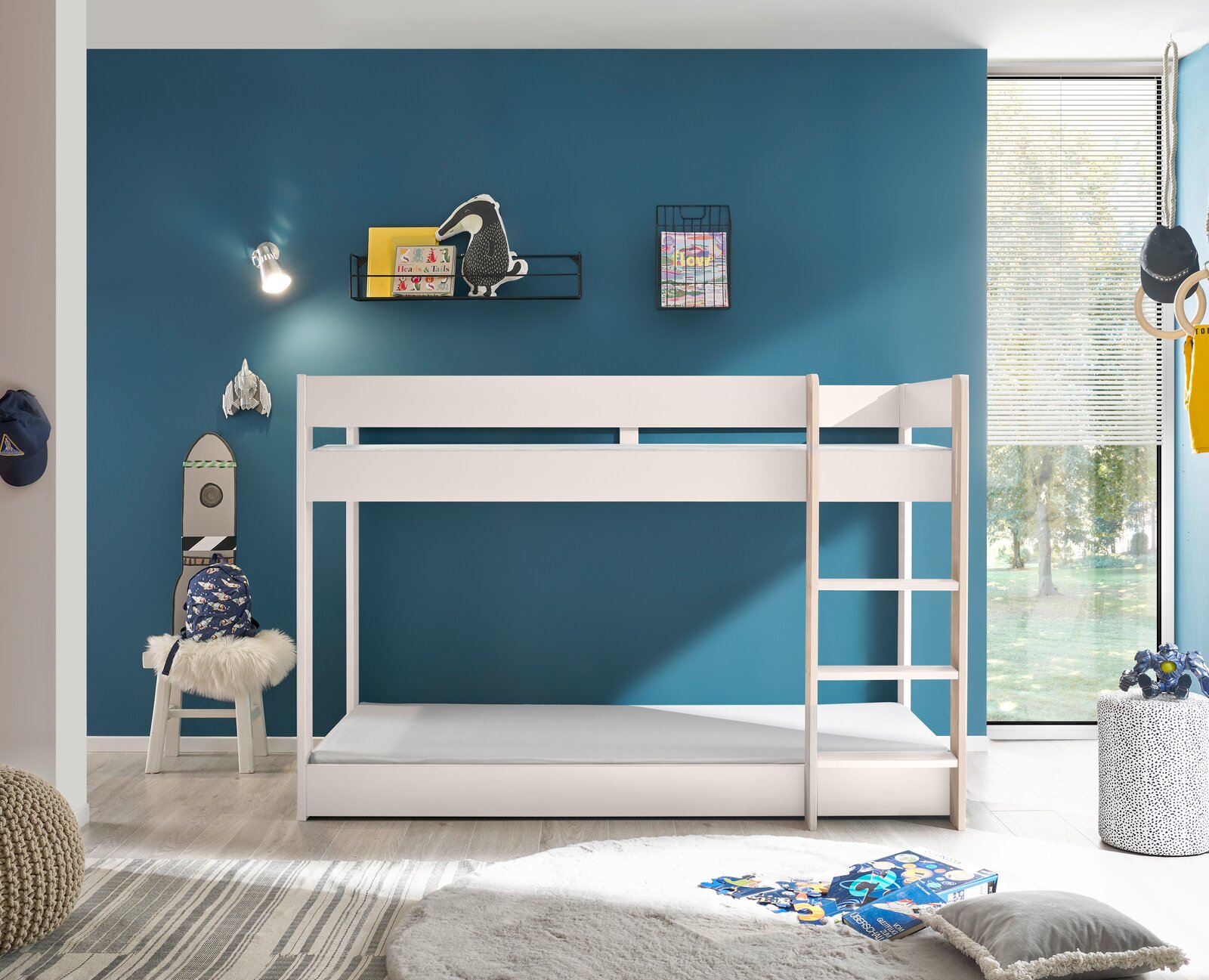 Weißes Etagenbett in einem modernen Kinderzimmer mit blauer Wand, seitlicher Perspektive