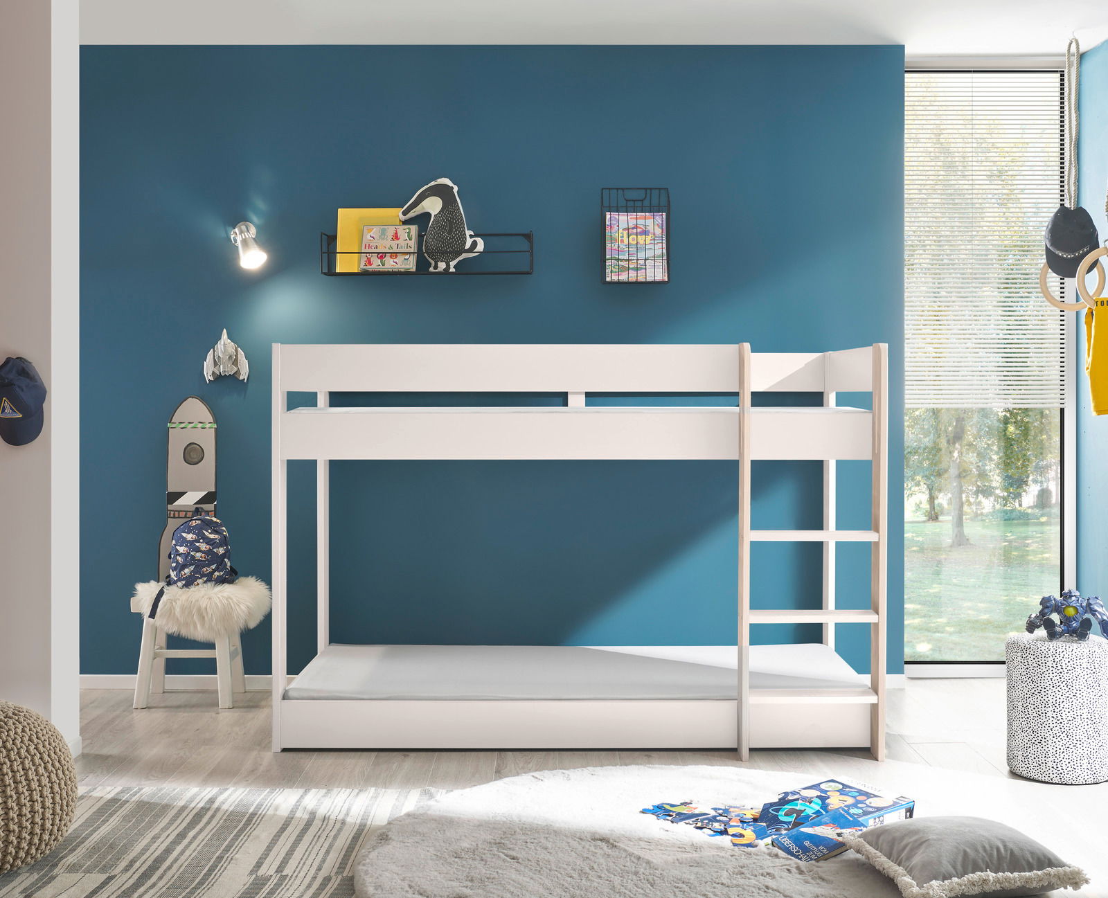 Weißes Etagenbett in einem modernen Kinderzimmer mit blauer Wand, seitlicher Perspektive