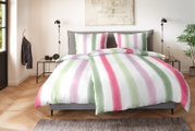 Gestreifte Bettwäsche in Weiß mit breiten Pastellstreifen in Grün, Rosa und Flieder auf einem grauen Polsterbett, frontal aus leichter Vogelperspektive im Schlafzimmer fotografiert.
