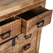 Nahaufnahme einer rustikalen Holzkommode mit offenen Schubladen und schwarzen Metallgriffen, Perspektive von schräg oben.