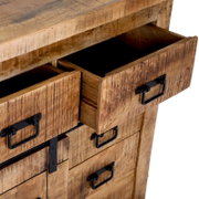 Close-up van een rustieke houten ladekast met open lades en zwarte metalen handgrepen, gezien vanuit een schuin bovenaanzicht.