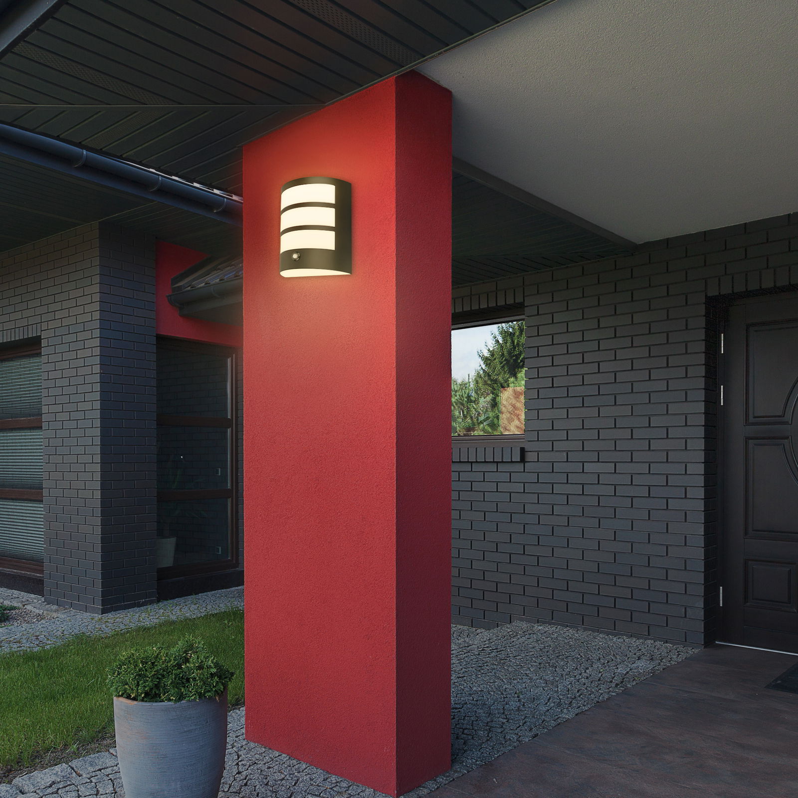 Briloner Akku-Außenwandleuchte Moderne Akku-Außenwandleuchte an einer roten Wand, seitliche Perspektive