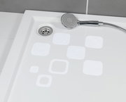 Blick von oben auf eine Duschwanne mit weißen, eckigen Anti-Rutschstickern und einer Handbrause.