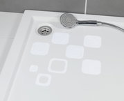 Blick von oben auf eine Duschwanne mit weißen, eckigen Anti-Rutschstickern und einer Handbrause.