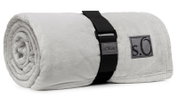 Graue, zusammengerollte Kuscheldecke von s.Oliver mit schwarzem Tragegurt, seitliche Perspektive