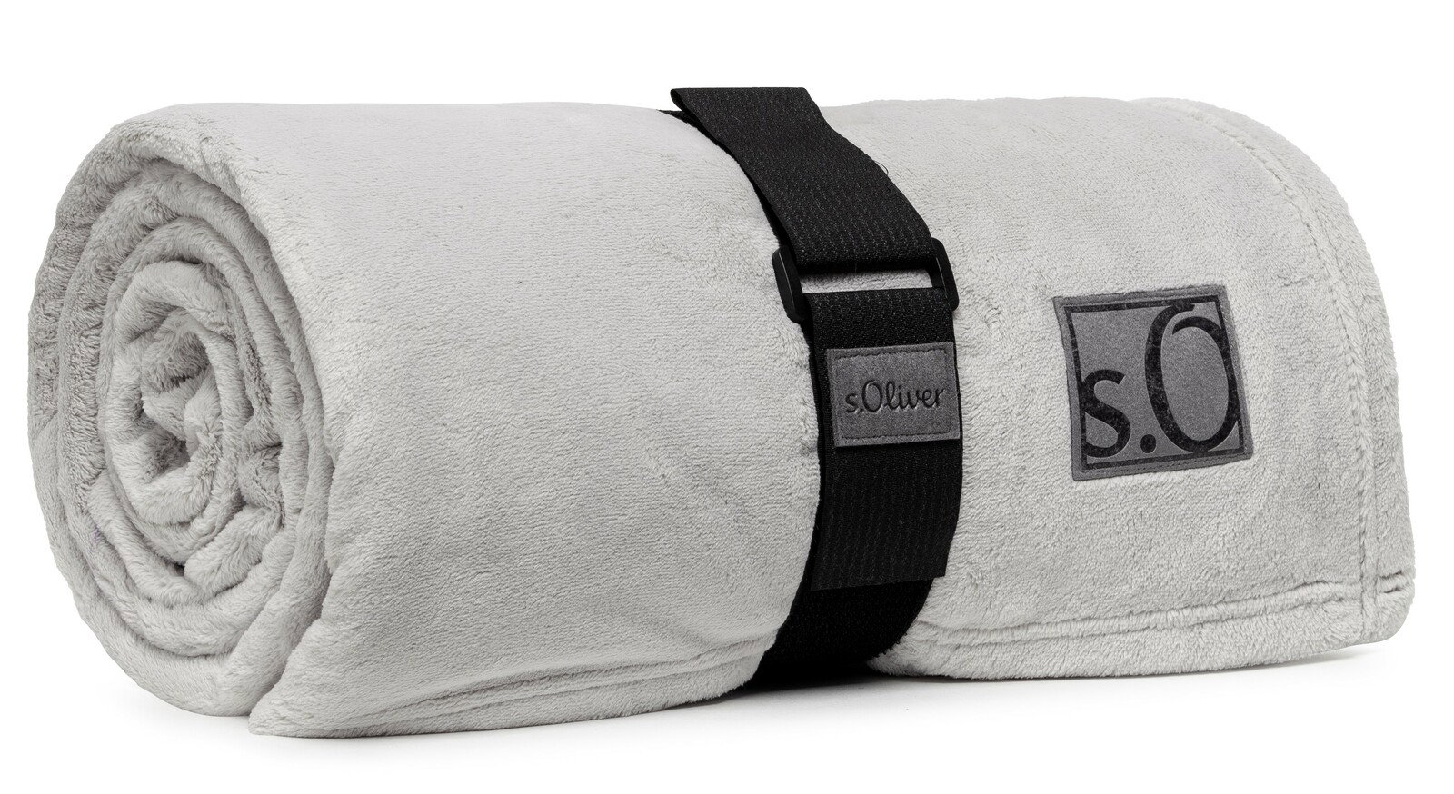 Graue, zusammengerollte Kuscheldecke von s.Oliver mit schwarzem Tragegurt, seitliche Perspektive
