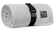 Graue, zusammengerollte Kuscheldecke von s.Oliver mit schwarzem Tragegurt, seitliche Perspektive