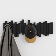 Moderne Wandgarderobe in Schwarz mit geometrischem Design, frontal betrachtet, mit aufgehängter Jacke und Mütze.