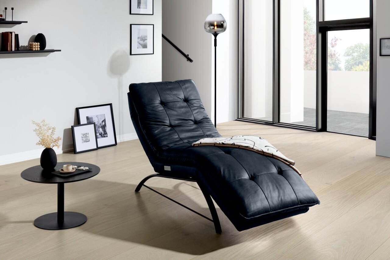 Elegante schwarze Liege in modernem Wohnzimmer, seitliche Perspektive