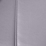 Nahaufnahme der grauen Lederoberfläche eines Massagesessels mit sichtbarer Naht.