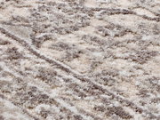 Nahaufnahme eines Designer-Teppichs mit weicher, flauschiger Textur in creme- und grautönen, diagonale Perspektive.