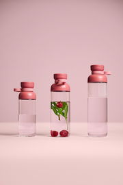 Drei Trinkflaschen der Serie VITA in Vivid Mauve, frontal fotografiert. Eine Flasche enthält Wasser mit Himbeeren und Minzblättern.