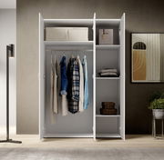 Drehtürenschrank 3-türig in moderner Inneneinrichtung, frontal geöffnet mit Kleidung und Regalfächern.