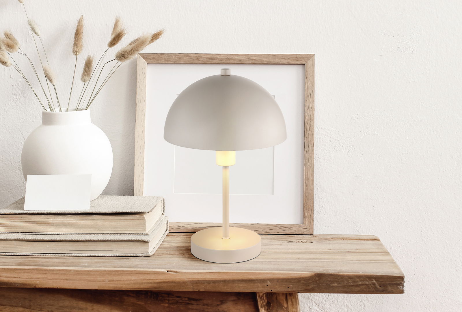 Moderne Tischleuchte mit rundem Schirm auf einem Holztisch, seitliche Perspektive
