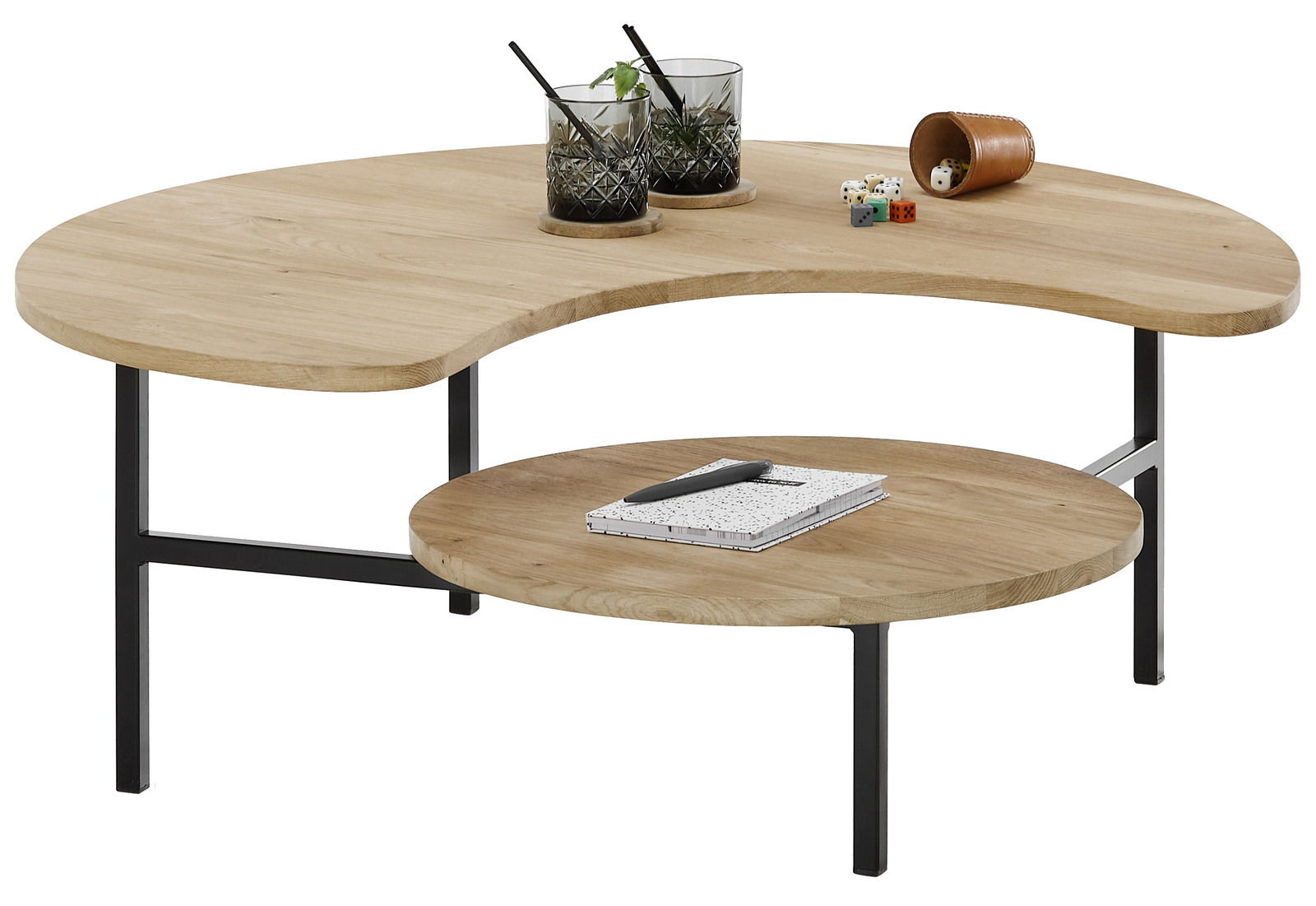 Moderner Couchtisch mit zwei Ebenen aus hellem Holz und schwarzem Metallgestell, von schräg oben fotografiert. Auf der oberen Ebene stehen zwei Gläser und Würfel, auf der unteren ein Notizbuch mit Stift.