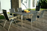 Moderner Klappsessel aus Metall und Holz auf einer Terrasse, seitliche Perspektive.