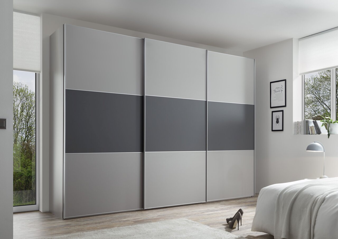 Moderner Schwebetürenschrank in Grau mit drei Türen, seitliche Perspektive im Schlafzimmer.
