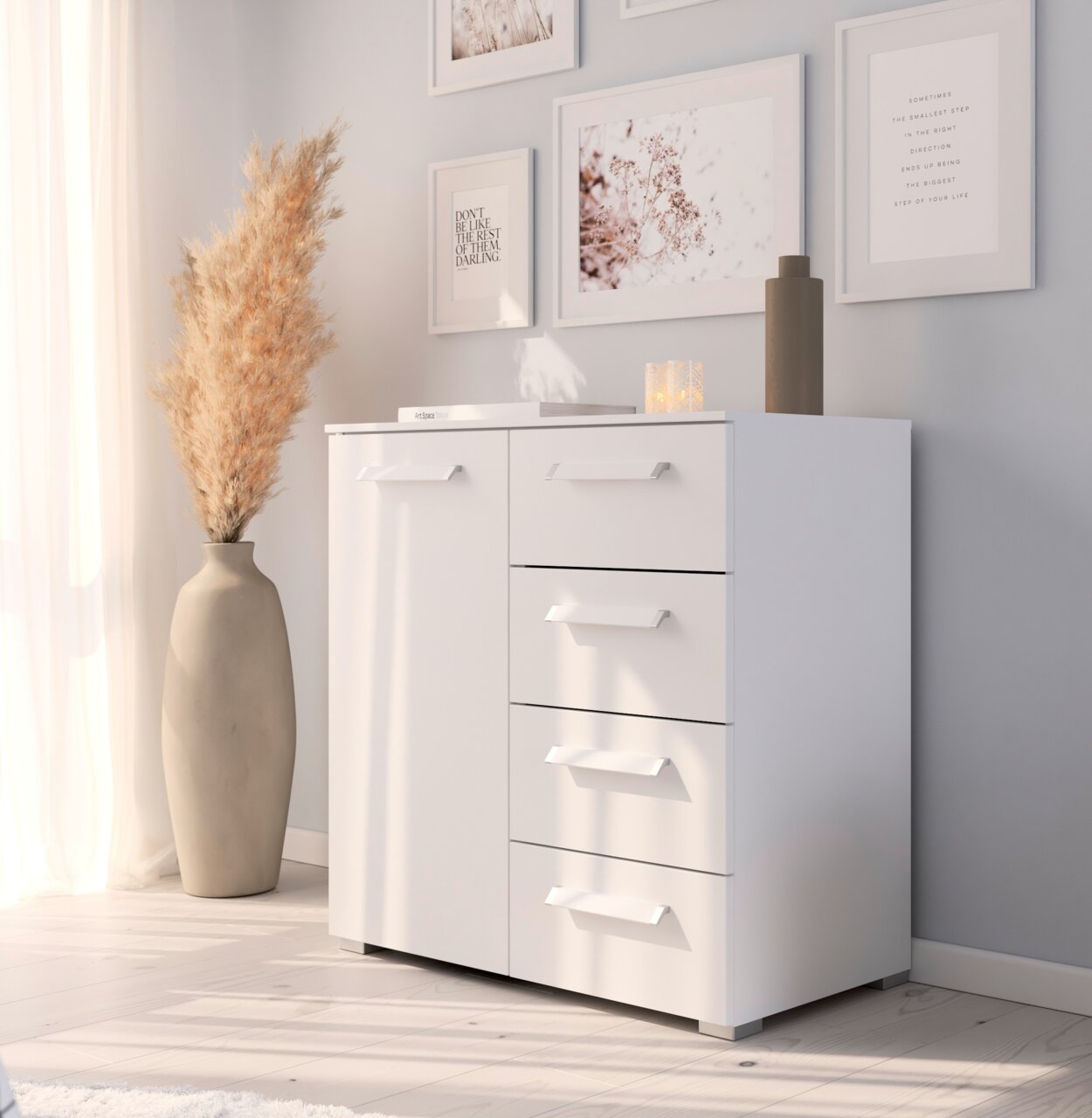 Weiße Kommode mit vier Schubladen und einer Tür, dekoriert mit einer Vase und Bildern an der Wand, aus seitlicher Perspektive fotografiert.