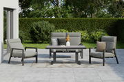 Gartenmöbel-Set mit zwei grauen Sesseln, einer grauen Gartenbank und einem Tisch auf einer Terrasse, umgeben von grüner Hecke und Bäumen, aus frontaler Perspektive.
