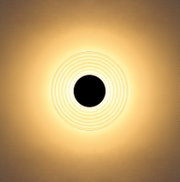 Runde Deckenleuchte mit konzentrischen Ringen und warmweißem Lichtschein an heller Decke, Ansicht von unten (Untersicht)