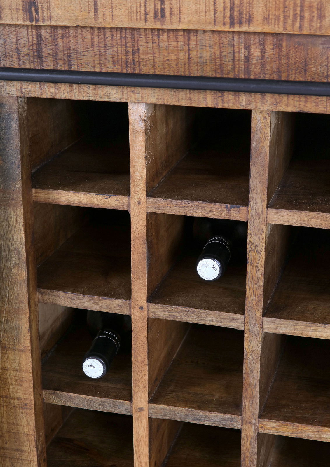Nahaufnahme eines Barschrankes aus Holz mit mehreren Fächern zur Lagerung von Weinflaschen, perspektivisch von vorne aufgenommen.