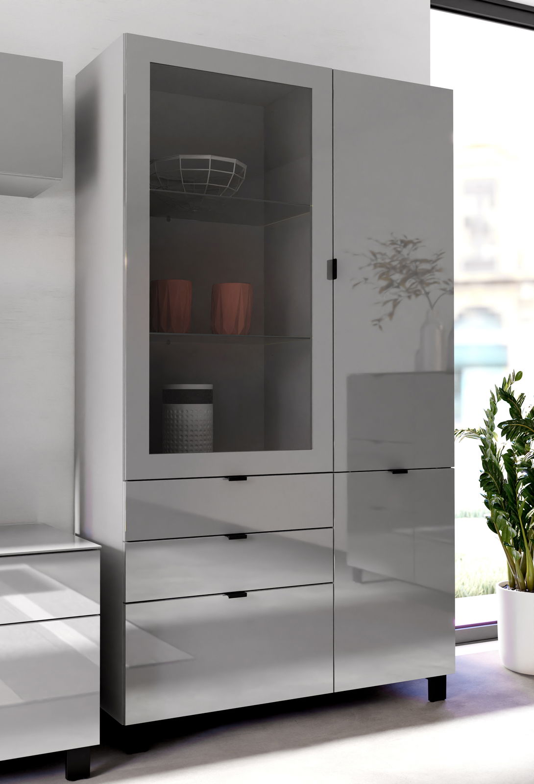 Moderne Vitrine in Hochglanzoptik mit Glastür und Schubladen, seitliche Perspektive