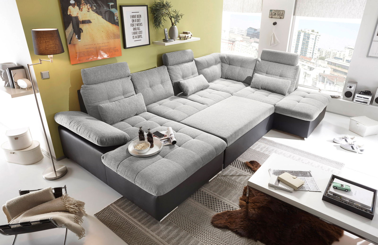 Moderne graue Rundecke mit verstellbaren Kopfstützen und gemütlichen Kissen, fotografiert aus einer leicht erhöhten Perspektive in einem stilvoll eingerichteten Wohnzimmer.