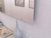 Moderner Wandspiegel in einem Raum mit Dekorationen, seitliche Perspektive