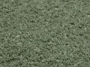 Nahaufnahme eines weichen, grünen Teppichs mit flauschiger Textur