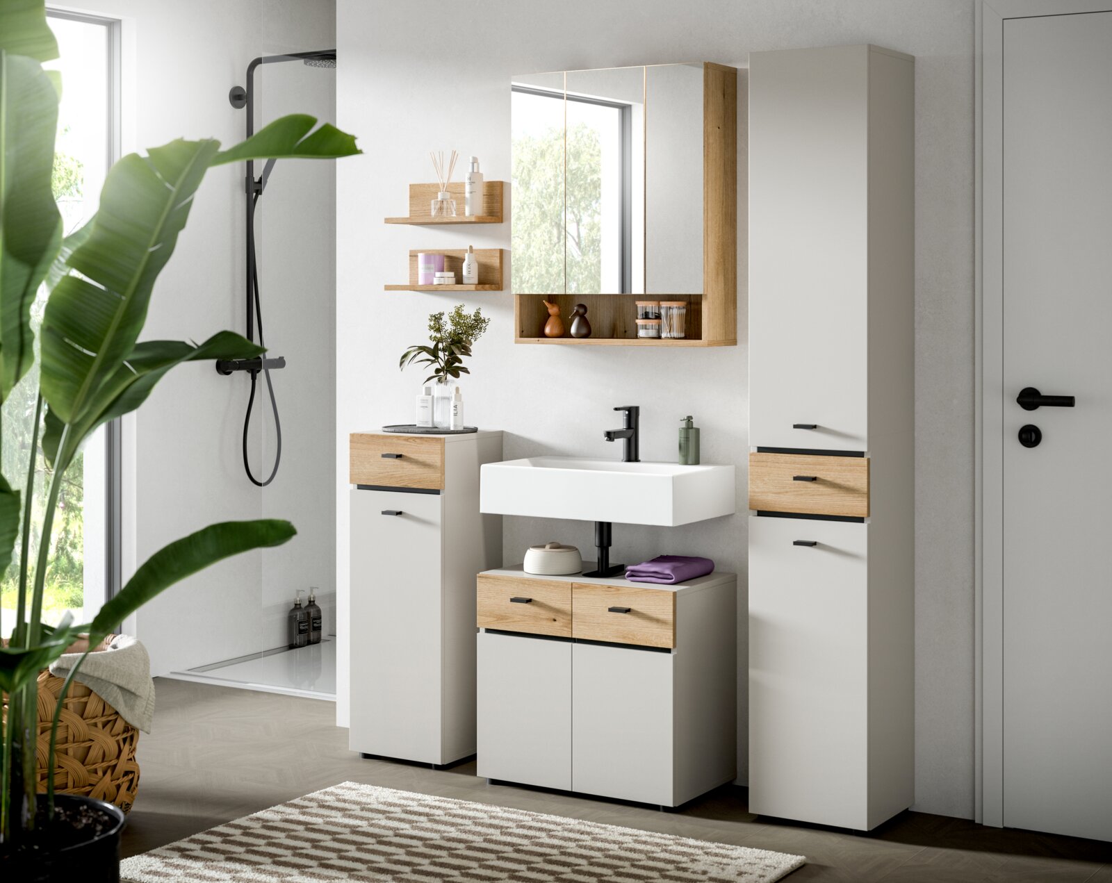 Modernes Badezimmermöbel-Set in Weiß mit Holzoptik-Fronten, Waschbecken und Spiegelschrank sowie Hochschrank; Aufnahme in frontaler, leicht seitlicher Perspektive.