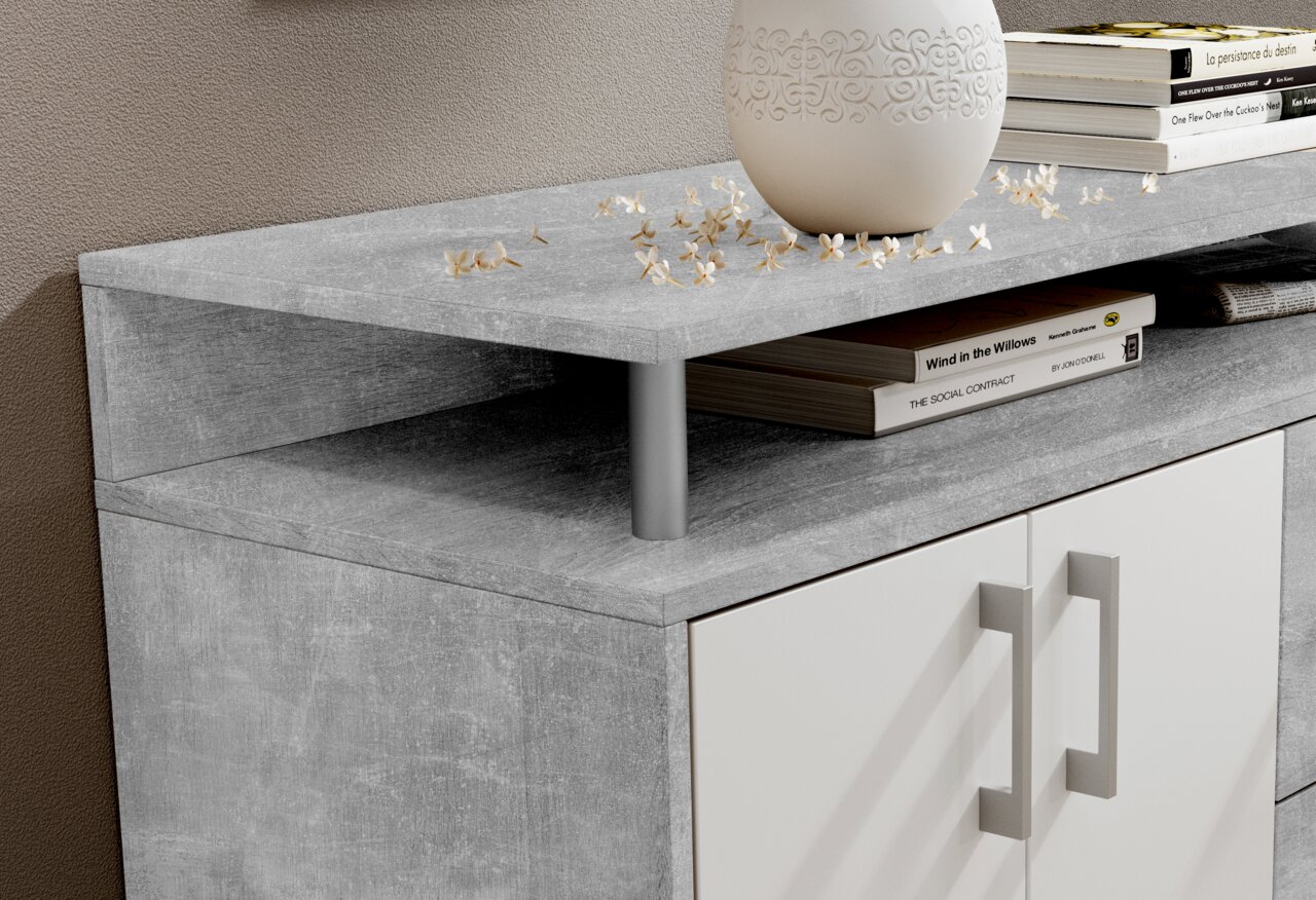 Nahaufnahme eines modernen Sideboards mit grauer Steinoptik-Oberfläche, dekoriert mit einem weißen Keramikgefäß und Büchern, aus seitlicher Perspektive.