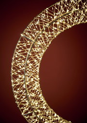 Nahaufnahme eines LED-Kranzes mit einem Durchmesser von 50 cm, der in einem warmen Licht leuchtet. Der Kranz ist aus einem filigranen Drahtgeflecht gefertigt und wird von zahlreichen kleinen LED-Lichtern erhellt. Die Perspektive zeigt den Kranz von der Se