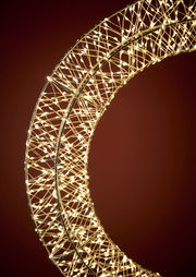 Nahaufnahme eines LED-Kranzes mit einem Durchmesser von 50 cm, der in einem warmen Licht leuchtet. Der Kranz ist aus einem filigranen Drahtgeflecht gefertigt und wird von zahlreichen kleinen LED-Lichtern erhellt. Die Perspektive zeigt den Kranz von der Se