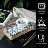 Sushi Set mit blauen Blumenmuster, bestehend aus Porzellantellern und Schalen, präsentiert auf einem Tisch mit Essstäbchen, aus der Vogelperspektive.