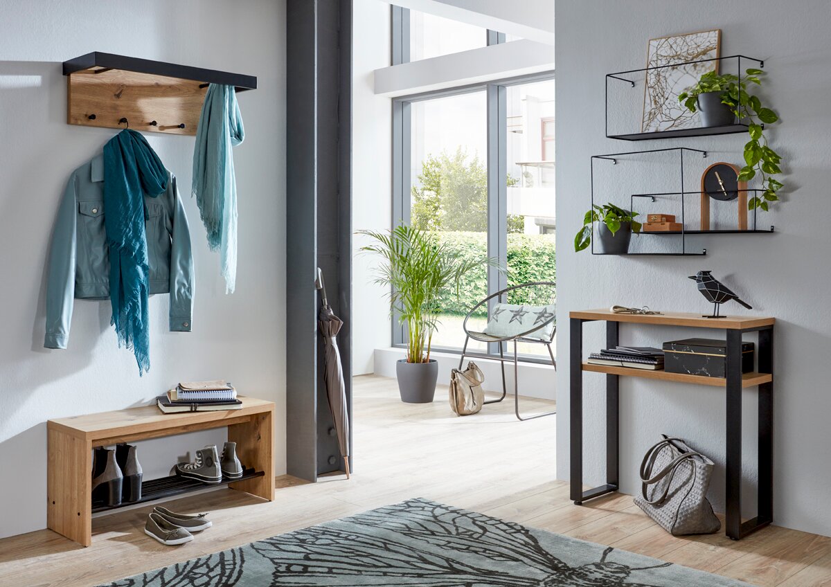 Modernes Eingangsbereich-Set mit Garderobenpaneel aus Holz und schwarzem Metall, Schuhbank, Konsolentisch und Wandregalen, frontal aus leicht seitlicher Perspektive fotografiert