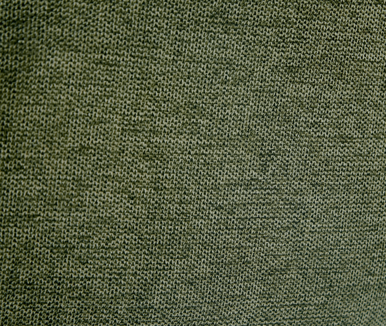 Nahaufnahme eines grünen Stoffes mit feiner Webstruktur, perspektivisch von oben betrachtet.