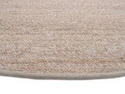 Nahaufnahme eines handgewebten Teppichs in natürlichen Beige- und Brauntönen, von der Seite fotografiert.