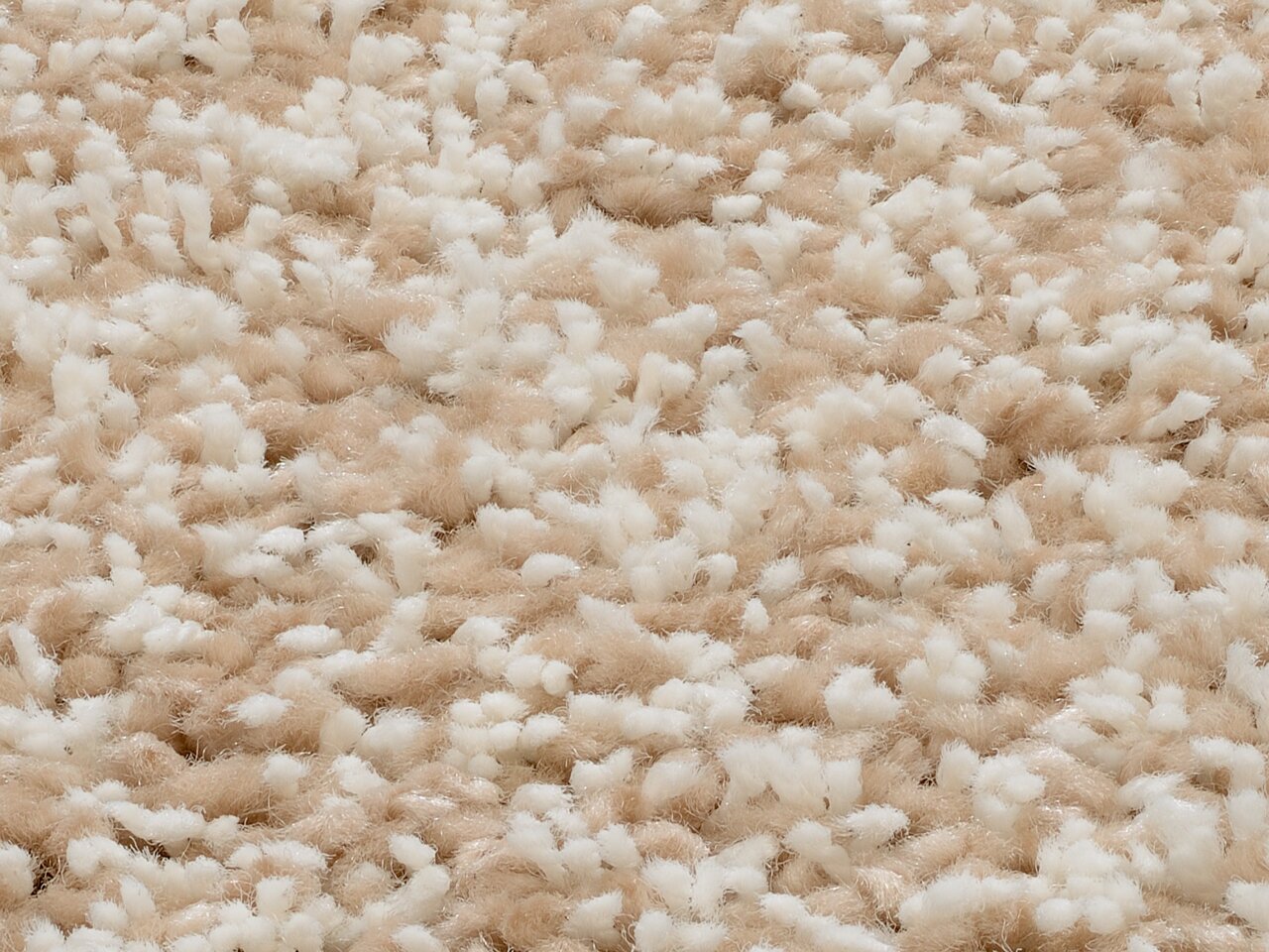 Nahaufnahme eines Hochflor-Teppichs in Beige und Weiß aus der Vogelperspektive