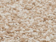 Nahaufnahme eines Hochflor-Teppichs in Beige und Weiß aus der Vogelperspektive