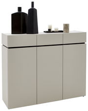 Breite Kommode in modernem Design mit drei Türen, dekoriert mit schwarzen Vasen und Kerzen, seitliche Perspektive