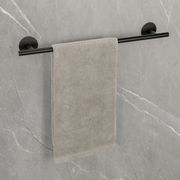 Badetuchstange Uno 60 cm in Schwarz, montiert an einer grauen Wand, mit einem grauen Handtuch. Perspektive: Frontalansicht.