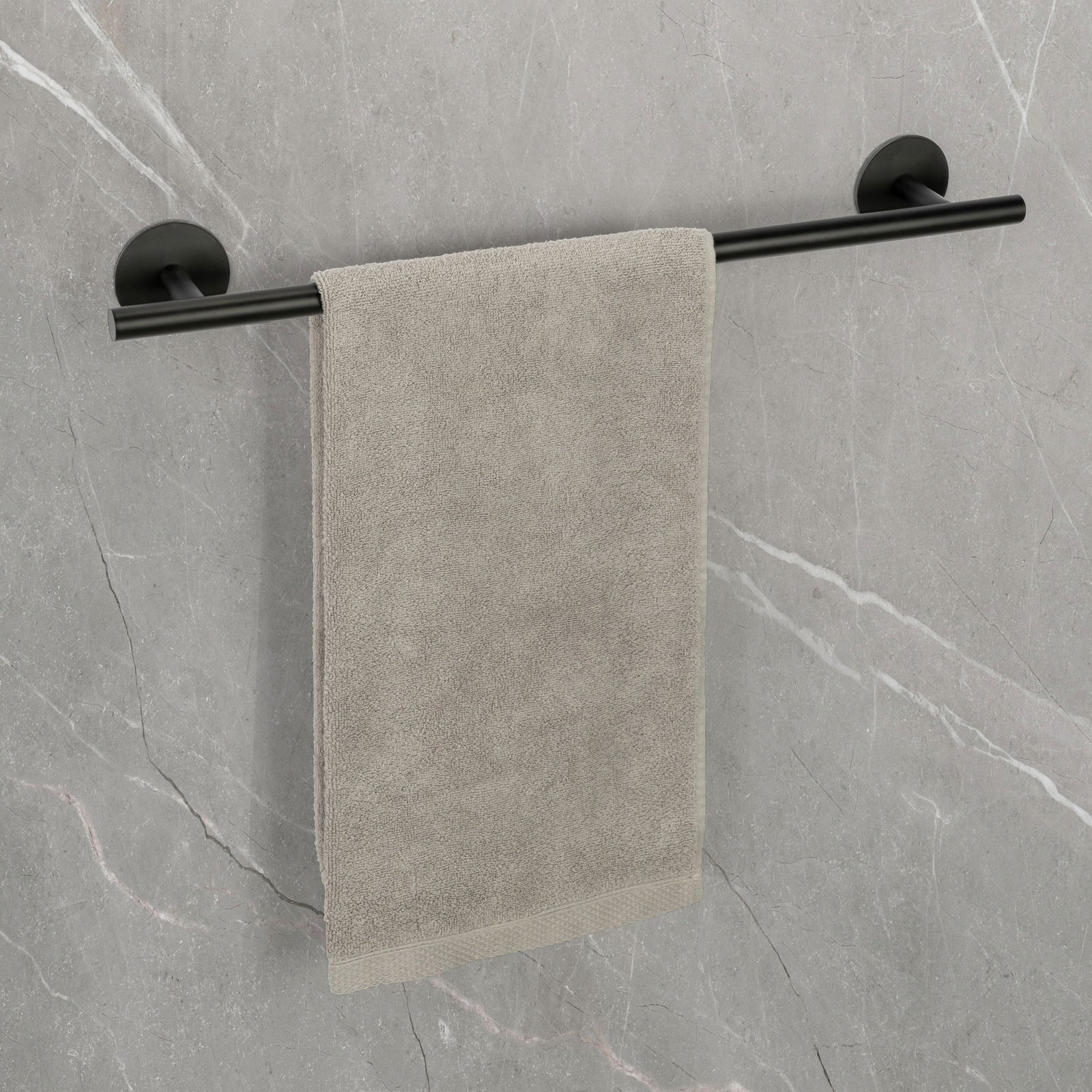 Badetuchstange Uno 60 cm in Schwarz, montiert an einer grauen Wand, mit einem grauen Handtuch. Perspektive: Frontalansicht.