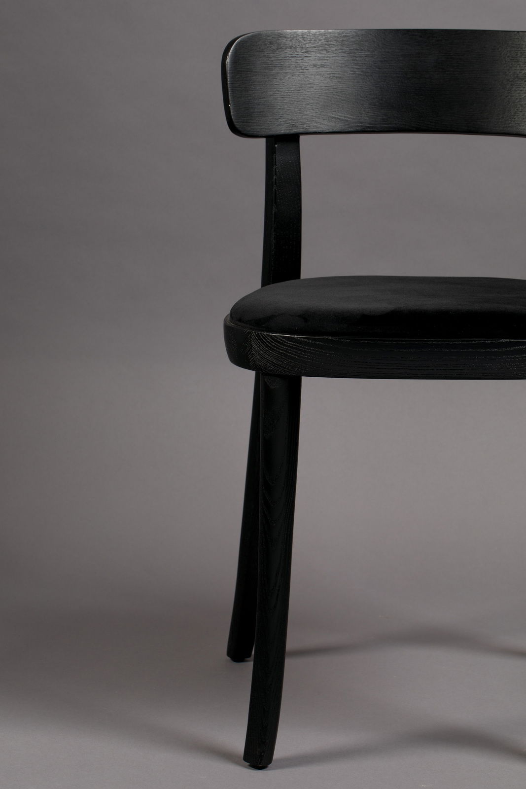 Schwarzer Holzstuhl mit gepolsterter Sitzfläche, seitliche Perspektive