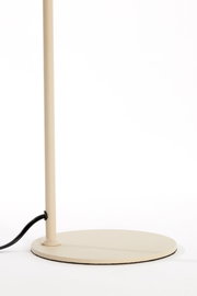 Detailaanzicht vanuit laag vooraanzicht van de ronde beige lampvoet met slanke staander en zwart snoer