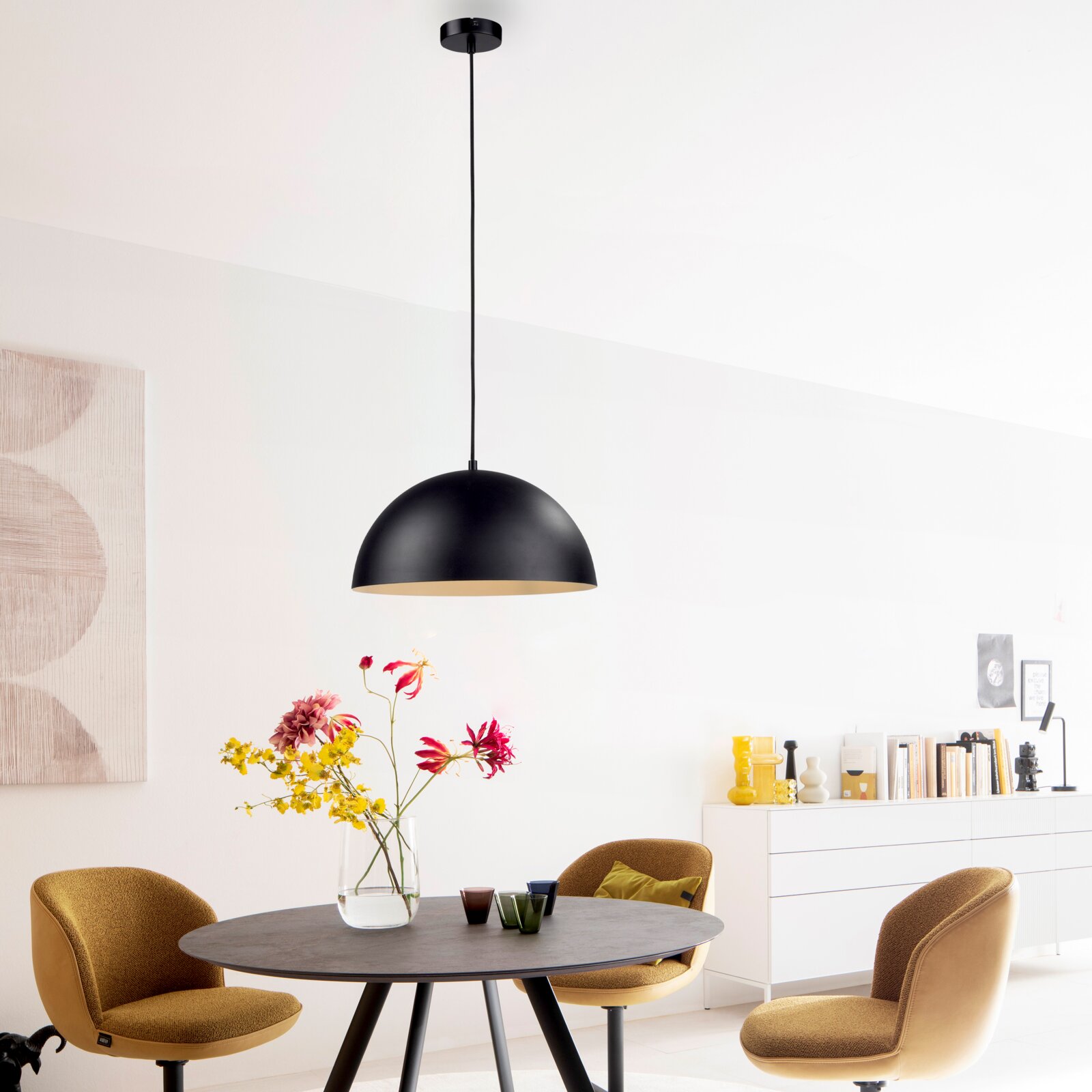 Schwarze, halbkugelförmige Pendelleuchte mit langem Kabel über einem Esstisch in modernem Esszimmer, frontale Innenraumaufnahme mit leichtem Blick von unten auf die Lampe