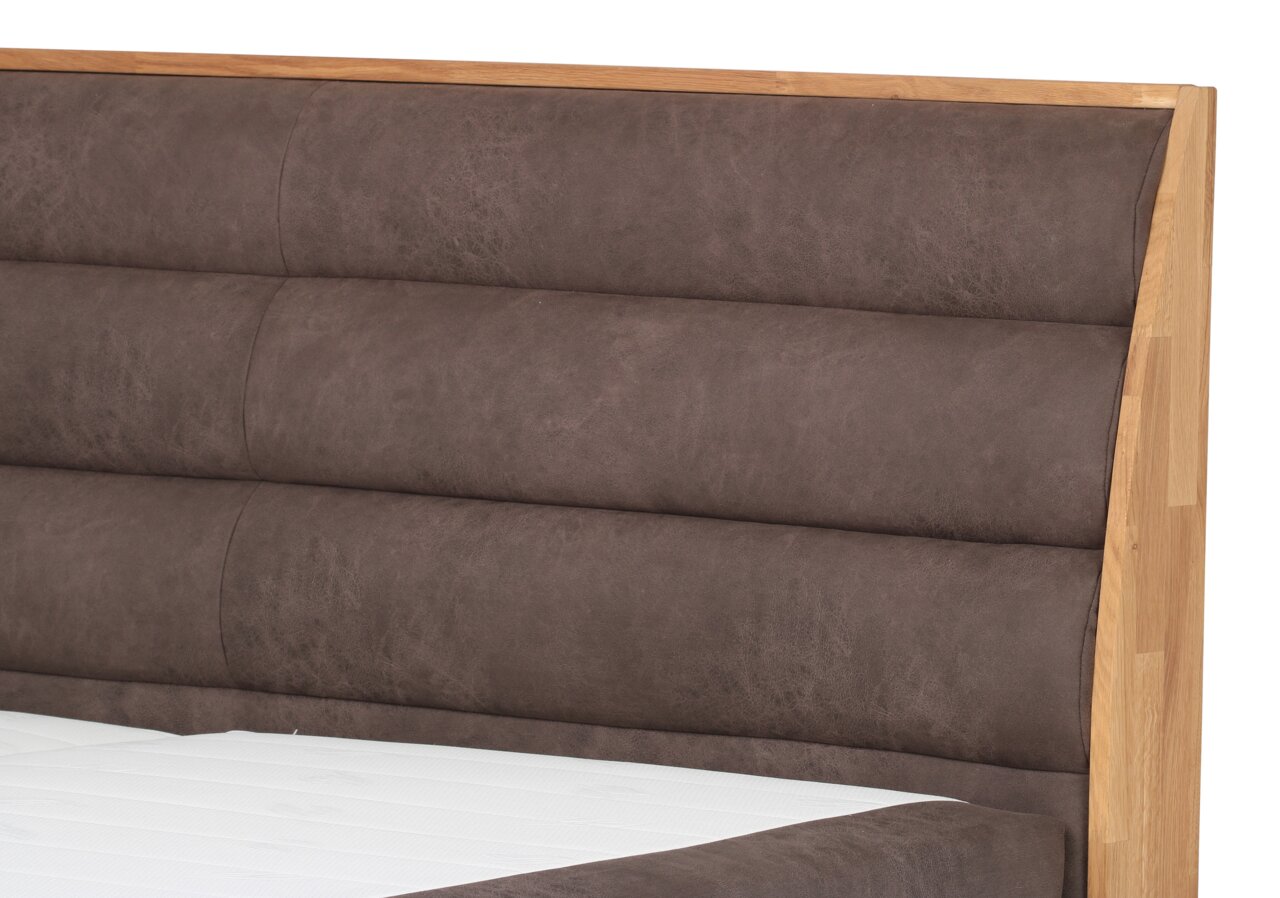 Close-up van een boxspringbed met een bruin, gestoffeerd hoofdeinde en een houten frame, gezien vanaf de zijkant