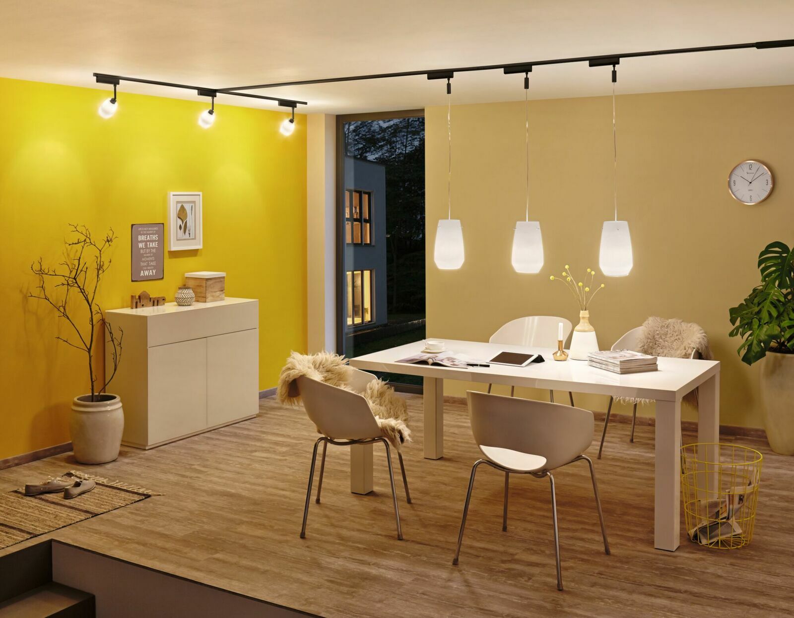 Moderner Wohnraum mit gelber Wand, stilvollen Möbeln und eleganter Beleuchtung von oben betrachtet.