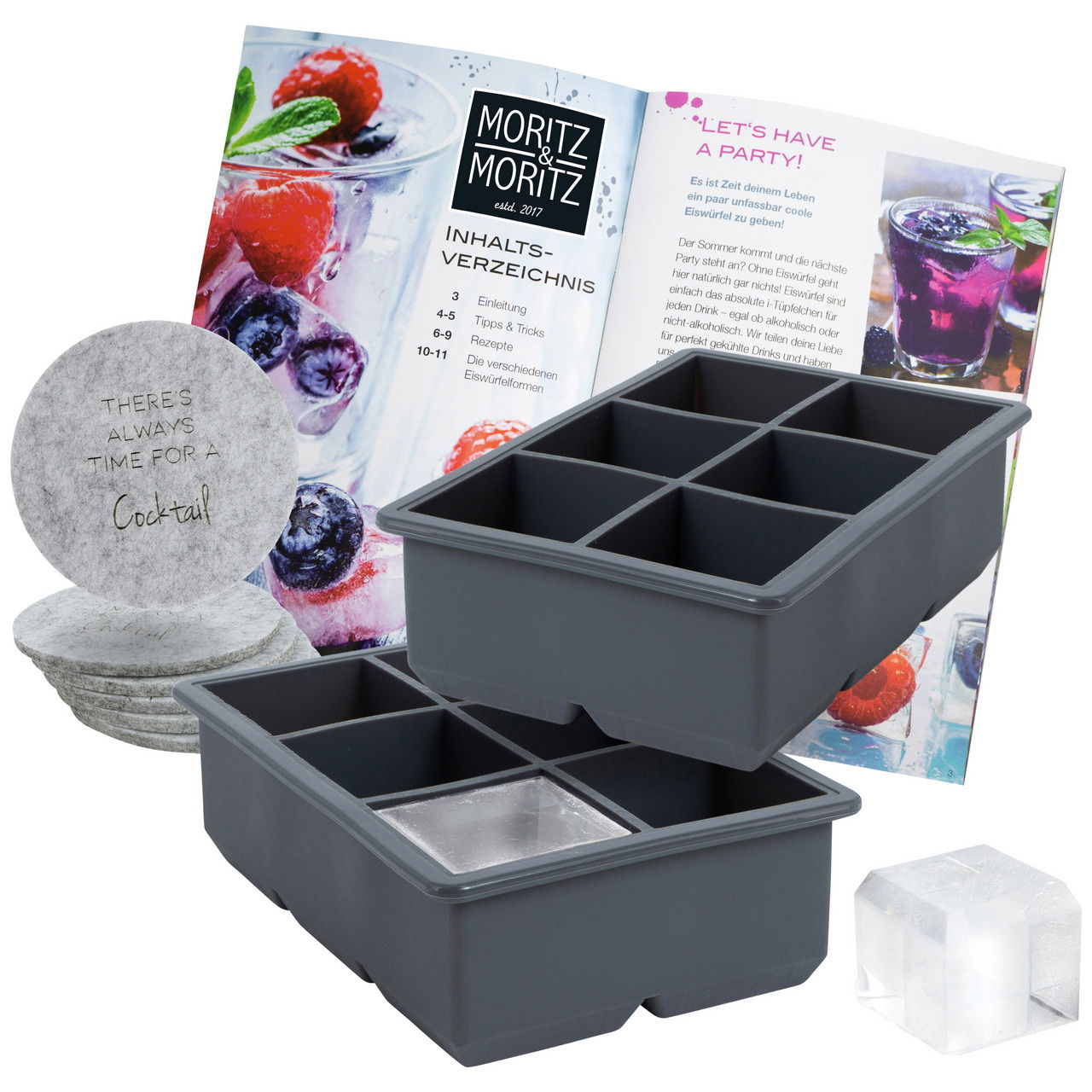 Zwei graue Eiswürfelformen mit quadratischen Fächern, begleitet von einem Rezeptbuch und runden Untersetzern. Perspektive von vorne.