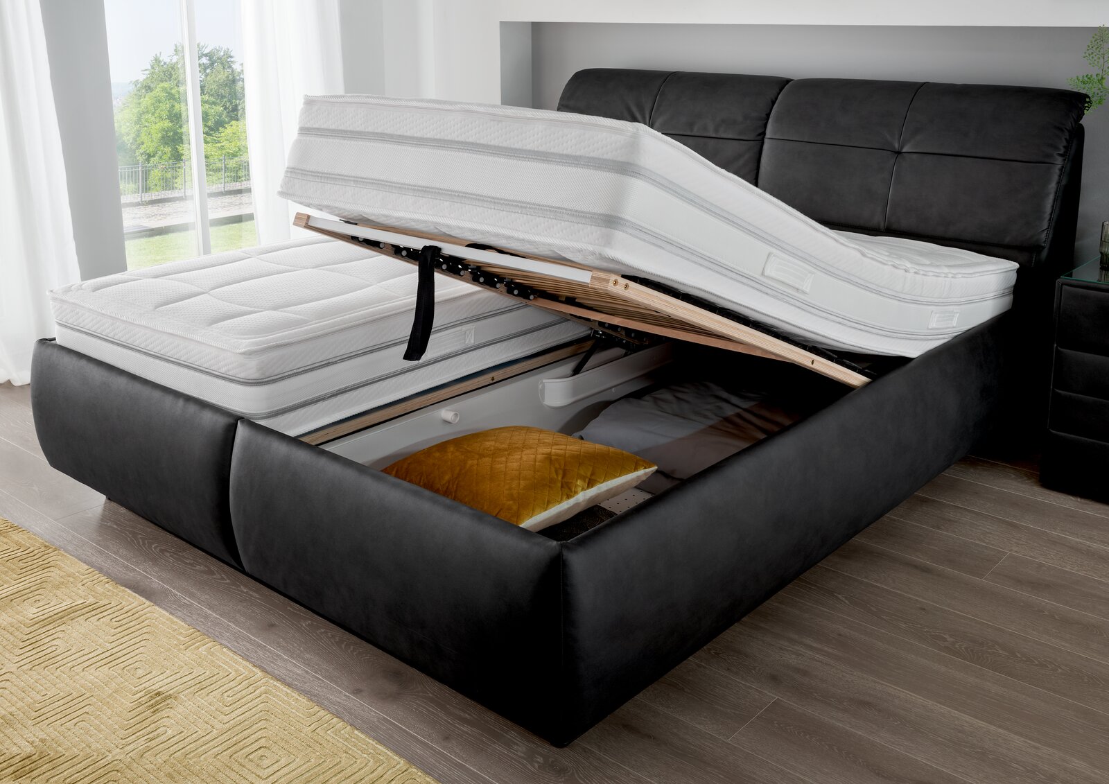 Polsterbett mit hochgeklappter Matratze und Stauraum, seitliche Perspektive